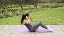 Woman doing sit-ups on a yoga mat in a park