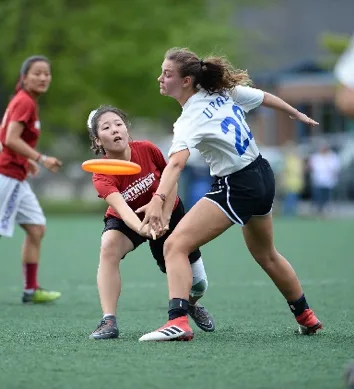 Two college ultimate-frisbee players competing for the disc during a match