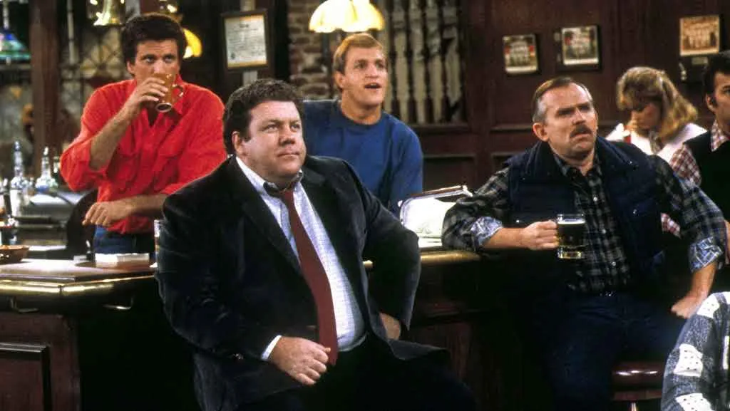 Cast of the TV show Cheers gathered around the bar drinking beer